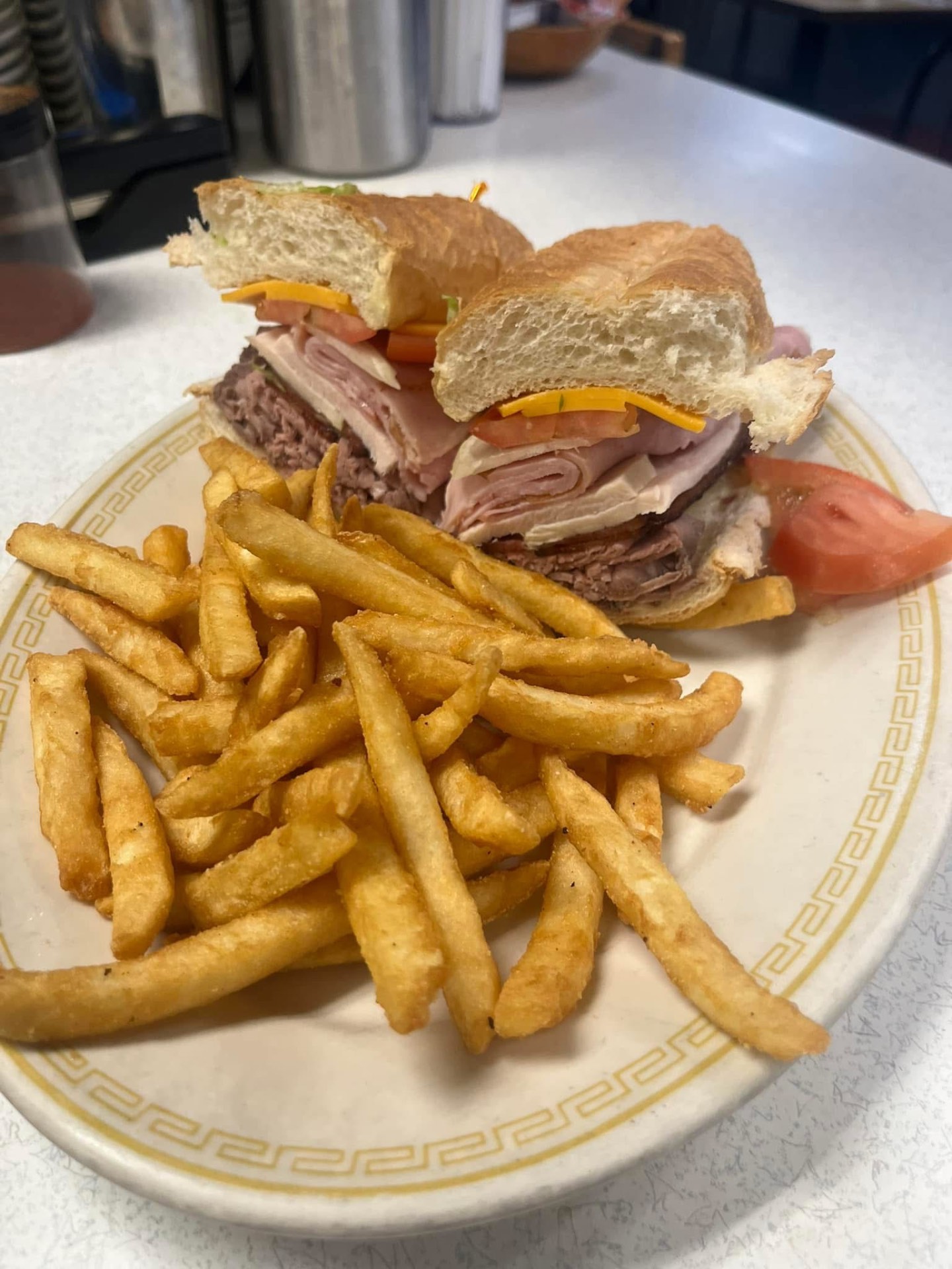 Club sandwich stacked with roast beef, turkey and ham, served with fries